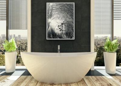 Schwarz-weiß Fotografie gebogener Gräser in der Sonne im weißen Schattenfugenrahmen über einer cremefarbenen Badewanne