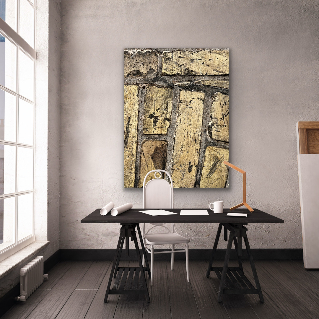 Detailfotografie einer gelben Mauer hinter einem braunen Schreibtisch in Industrieloft