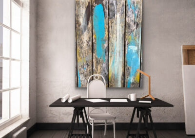 Detailfotografie der Oberfläche eines Holztisches in blau-braun-gelben Farbtönen als großformatiges Leinwandbild an grauer Wand hinter einem schwarzen Schreibtisch.