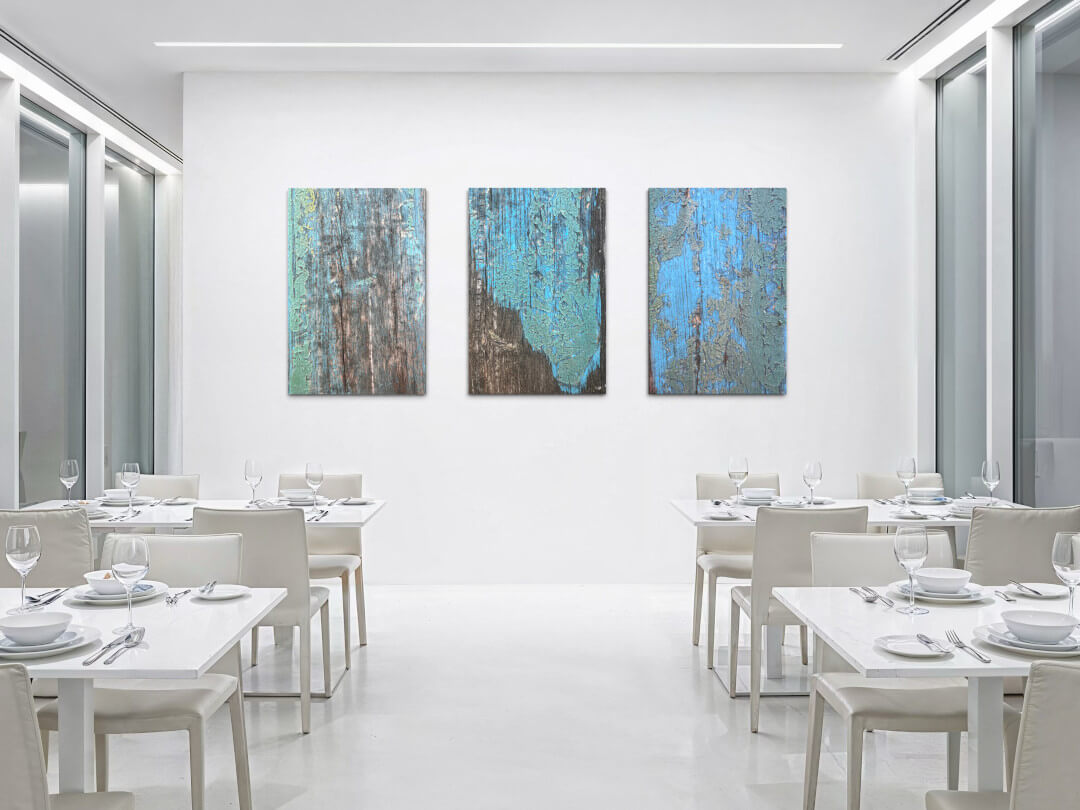 Kunst für Hotellerie und Gastronomie Bild 2 Drei Detailfotografien in Blau- und Grüntönen in einem hellen, in weiß gehaltenem Speisesaal.