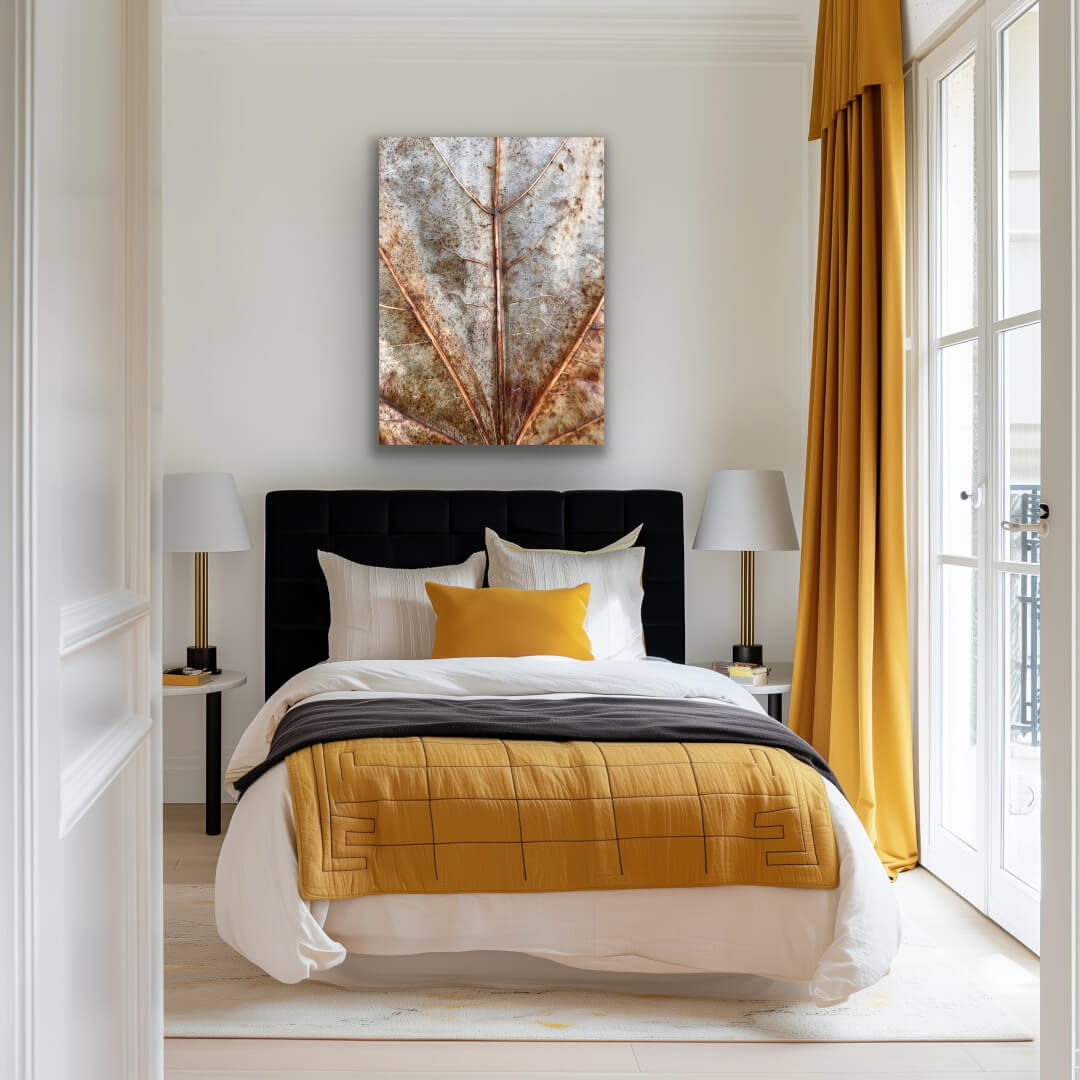 Detailfotografie eines Laubblattes in Rost-Orange-Tönen über einem Bett