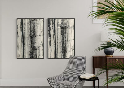 Schwarz-weiß Fotografien im Schattenfugenrahmen an grauer Wand über einem schwarz-weiß kariertem Sessel