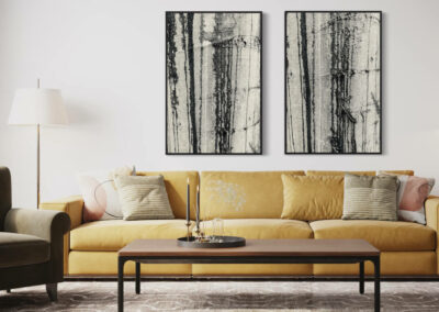 Zwei Schwarz-weiß Fotografien von Regen auf einem Baumstamm im schwarzen Schattenfugenrahmen über einer gelben Couch