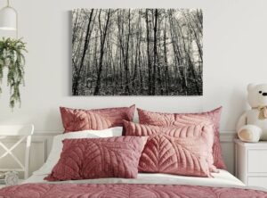 Schwarz-weiß Fotografie eines Waldes über einem Doppelbett mit altrosé farbenen Kissen