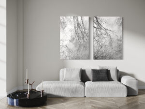 Zwei Schwarz-weiß Fotografien einer Wasserspiegelung an weißer Wand über einer beigen Couch